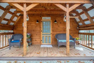 a wooden cabin with two chairs and a door at ForgetMeNot in Wellington