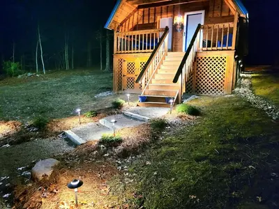 a cabin with a staircase in a yard at night at ForgetMeNot in Wellington