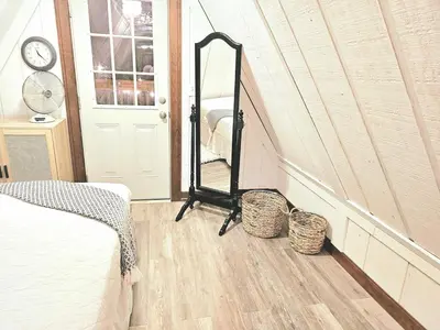 a bedroom with a mirror next to a door at ForgetMeNot in Wellington