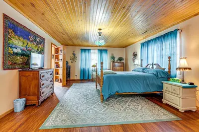 a bedroom with a bed and a wooden ceiling at Secluded, Waterfront Home with Patio in Craigville!