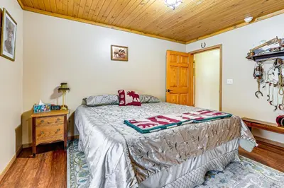 a bedroom with a bed and a wooden ceiling at Secluded, Waterfront Home with Patio in Craigville!