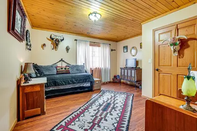 a bedroom with a bed and a wooden ceiling at Secluded, Waterfront Home with Patio in Craigville!