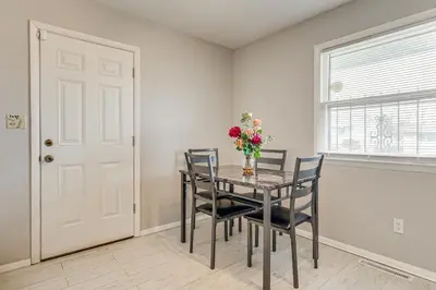 a dining room with a table with chairs and a vase of flowers at 6 Mi to Downtown Columbus Quiet Home with Yard in Columbus