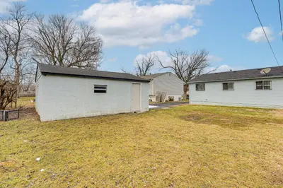 a white house with a garage in a yard at 6 Mi to Downtown Columbus Quiet Home with Yard in Columbus