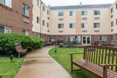 a park bench in front of a building at MainStay Suites Pittsburgh Airport in Imperial