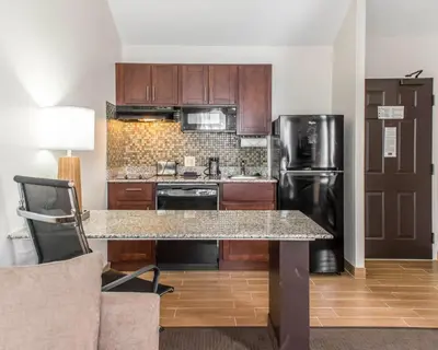 a kitchen with a counter and a refrigerator at MainStay Suites Pittsburgh Airport in Imperial
