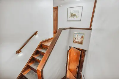 a set of stairs with a wooden stair case at 3rd Floor Retreat Near Cleveland Clinic & Downtown in Shaker Heights