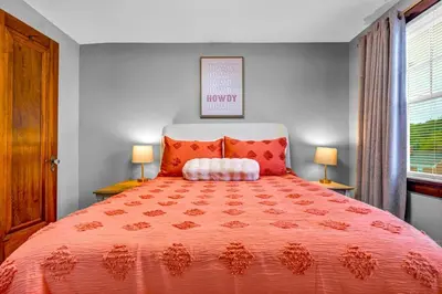 a bedroom with a large orange bed with two lamps at 3rd Floor Retreat Near Cleveland Clinic & Downtown in Shaker Heights