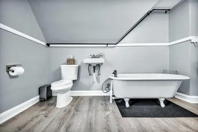 a bathroom with a tub and a toilet and a sink at 3rd Floor Retreat Near Cleveland Clinic & Downtown in Shaker Heights