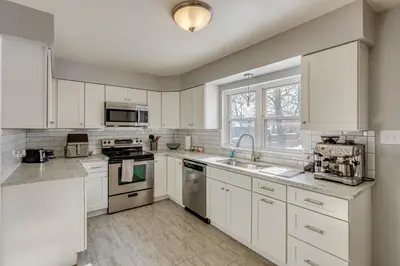 a kitchen with white cabinets and white appliances at Cincy Area Bungalow with Deck and Yard, Pets Welcome! in Covington