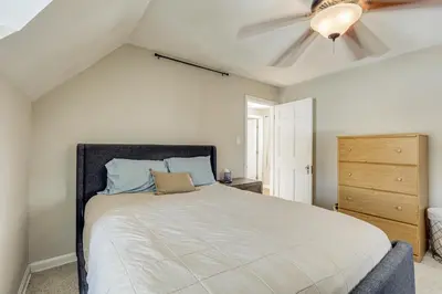 a bedroom with a bed and a ceiling fan at Cincy Area Bungalow with Deck and Yard, Pets Welcome! in Covington