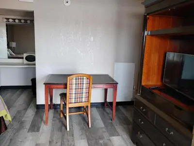 a dining room table with a chair and a tv at Millbury Motel in Millbury