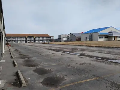 an empty parking lot with buildings in the background at Millbury Motel in Millbury