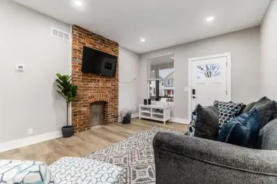 a living room with a couch and a brick fireplace at 230 Entire Complex 2 homes side by side in Columbus