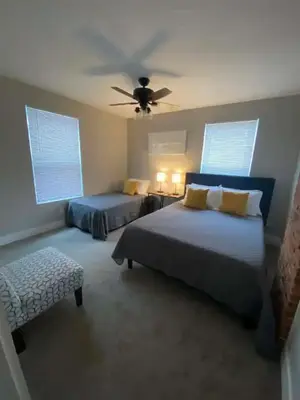 a bedroom with two beds and a ceiling fan at 230 Entire Complex 2 homes side by side in Columbus