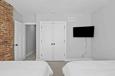 a white bedroom with two beds and a flat screen tv at 293 Perfect for companies in Columbus