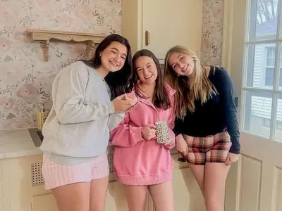 three women standing next to each other in a room at Peaches and Cream Coffee and Confetti Villa in Dayton