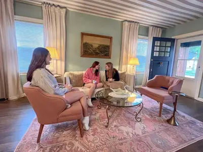 two women sitting on a couch in a living room at Peaches and Cream Coffee and Confetti Villa in Dayton
