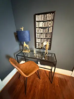 a desk with a chair and a glass table with a lamp at The Study in Chillicothe