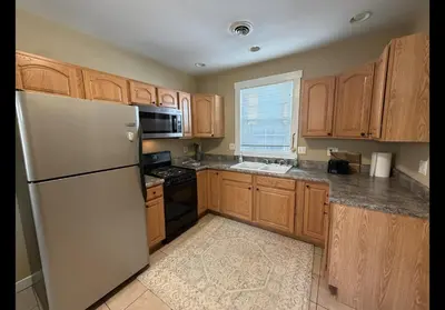 a kitchen with wooden cabinets and a white refrigerator at The Study in Chillicothe