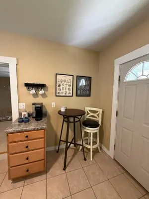 a kitchen with a table and a stool next to a door at The Study in Chillicothe