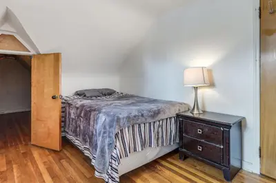 a bedroom with a bed and a lamp and a dresser at 3 Mi to UD and Kettering Health! Suburban Stay in Dayton