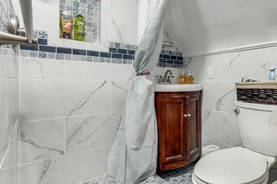 a bathroom with a toilet and a sink with a shower curtain at 3 Mi to UD and Kettering Health! Suburban Stay in Dayton