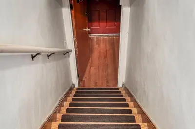 a hallway with a red door and a stairway at 3 Mi to UD and Kettering Health! Suburban Stay in Dayton
