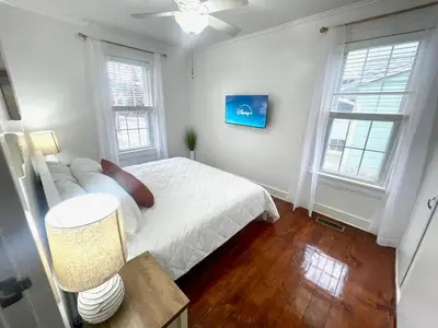 a bedroom with a white bed and two windows at Coastal Cape Cod w/ King Bed, Game Room, & Bikes! in Vermilion