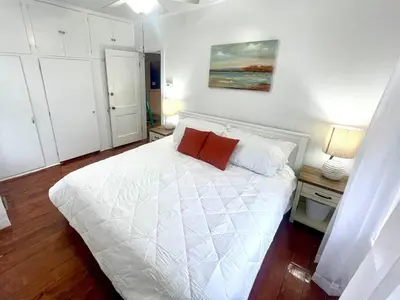 a bedroom with a white bed with two red pillows at Coastal Cape Cod w/ King Bed, Game Room, & Bikes! in Vermilion