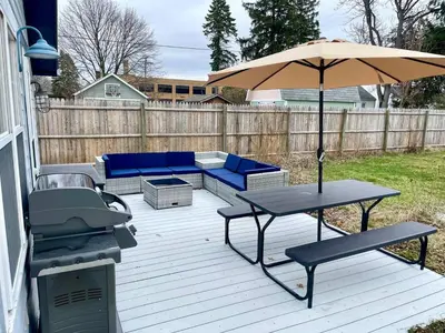 a patio with a table and an umbrella at Coastal Cape Cod w/ King Bed, Game Room, & Bikes! in Vermilion