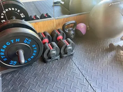 a bunch of dumbbells on a rack in a gym at Coastal Cape Cod w/ King Bed, Game Room, & Bikes! in Vermilion