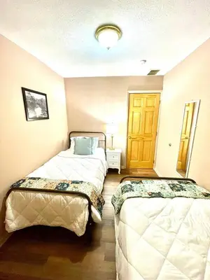 a room with two beds and a door at Vintage, Mid-Century Suite above Antique Store in Wakeman