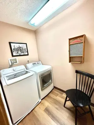 a laundry room with a washer and a microwave at Vintage, Mid-Century Suite above Antique Store in Wakeman