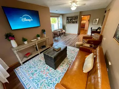 a living room with a couch and a flat screen tv at Vintage, Mid-Century Suite above Antique Store in Wakeman