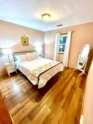 a bedroom with a large bed and a wooden floor at Vintage, Mid-Century Suite above Antique Store in Wakeman