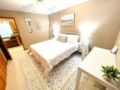 a bedroom with a white bed and a table and a bed sidx sidx sidx sidx at Spacious King Bed Suite at Antique Store in Wakeman