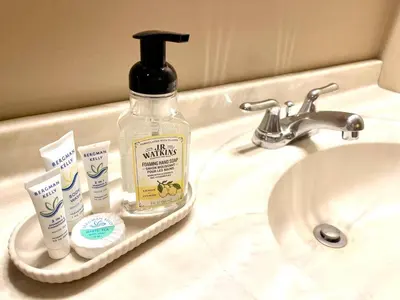 a bathroom sink with a bottle of mouthwash and toothpaste at Spacious King Bed Suite at Antique Store in Wakeman