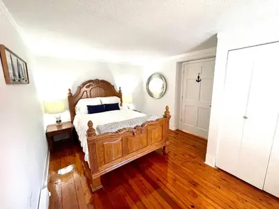 a bedroom with a wooden bed with a wooden floor at ENTIRE UNIT- Charming Century Home in Harbour Town in Vermilion