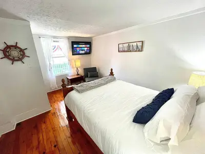 a bedroom with a large white bed and a window at ENTIRE UNIT- Charming Century Home in Harbour Town in Vermilion