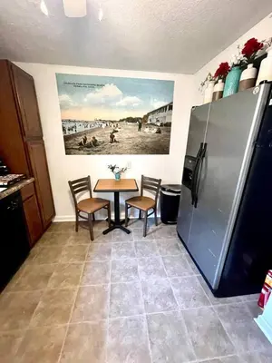 a kitchen with a table and a refrigerator at ENTIRE UNIT- Charming Century Home in Harbour Town in Vermilion