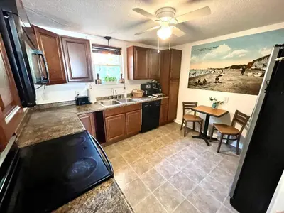 a kitchen with a sink and a table in it at ENTIRE UNIT- Charming Century Home in Harbour Town in Vermilion