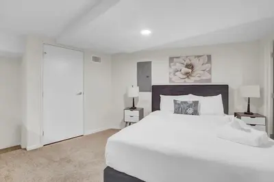 a white bedroom with a large bed and two lamps at LoFi Loft Life DT Cleveland Gym Terrace in Cleveland