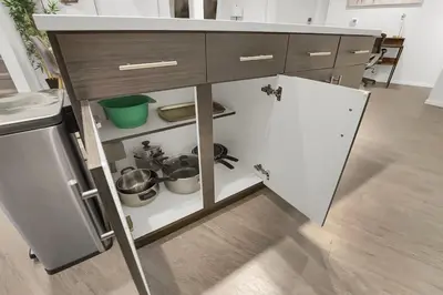 a kitchen with an open cabinet with pots and pans at LoFi Loft Life DT Cleveland Gym Terrace in Cleveland
