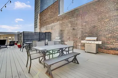 a patio with a table and chairs and a grill at LoFi Loft Life DT Cleveland Gym Terrace in Cleveland