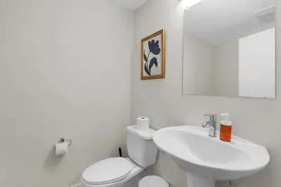 a white bathroom with a toilet and a sink at LoFi Loft Life DT Cleveland Gym Terrace in Cleveland