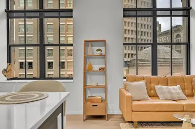 a living room with a couch and large windows at Black & Tan Bold Style Smooth Finish Served Daily in Cleveland