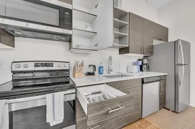 a kitchen with stainless steel appliances and wooden cabinets at Black & Tan Bold Style Smooth Finish Served Daily in Cleveland
