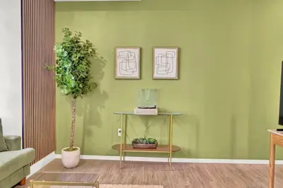 a living room with a table and a green wall at The Dirty Martini Den Classic style Extra Dirty in Cleveland