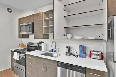 a kitchen with white cabinets and a sink at The Dirty Martini Den Classic style Extra Dirty in Cleveland